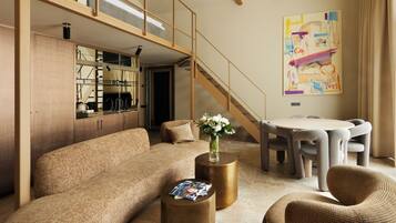 A modern living room with a sofa, coffee table, and a dining area with chairs and a table.