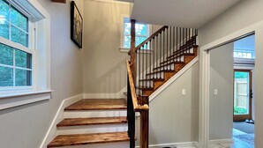 A wooden staircase with a black handrail leading to a landing. - The Barnhouse with hot tub (New Gloucester)