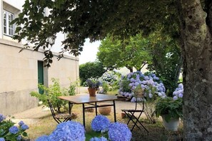Relax in a serene garden setting surrounded by lush greenery and flowering plants.