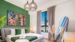 Una camera d'albergo moderna con un letto grande, pareti verdi e opere d'arte.