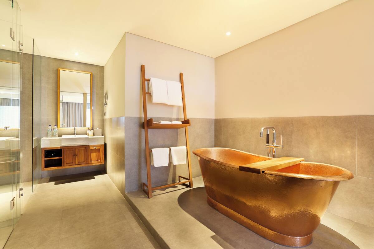 A modern bathroom with a freestanding bathtub, a glass shower enclosure, and a wooden vanity with a mirror.