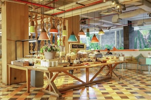 Un café avec une table en bois, des lampes suspendues et un sol à carreaux.