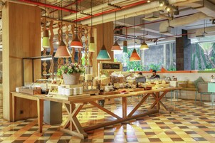 A cafe with a wooden table, hanging pendant lights, and a checkered floor.