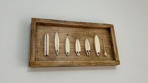 Un plateau en bois contenant six objets blancs et une cuillère.