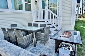 An outdoor patio with a glass-top table and wicker chairs, a barbecue grill, and a gas tank. - Rehoboth Beach 6BR Luxury House with Ultimate Entertainment Rm w 5,000+ sqft (Rehoboth Beach)