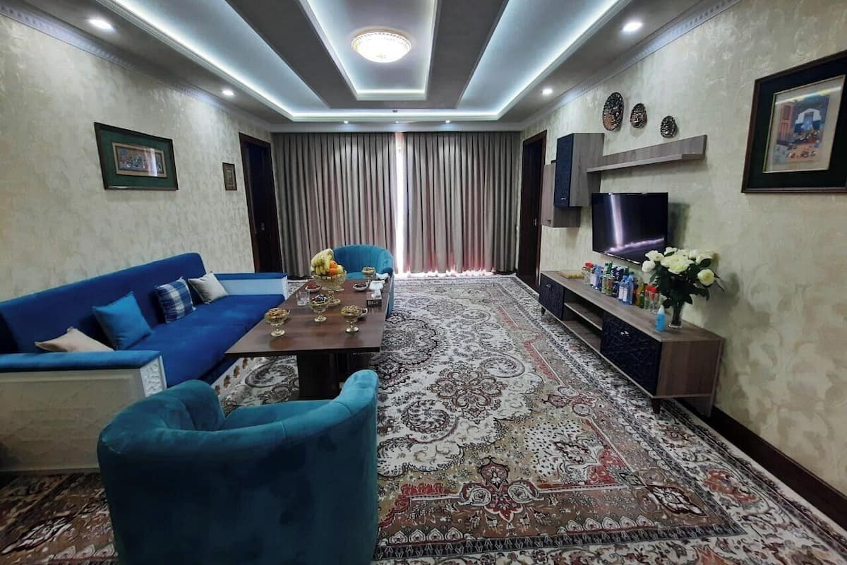 A modern living room with a sofa, a coffee table, and a TV.