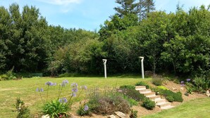 Un jardin avec un sentier en pierre menant à un belvédère.