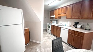 A kitchen with wooden cabinets, a white refrigerator, a stove, and a marble countertop. - Federal Ct- Charming 3-bedroom near Ag Center and MTSU in Murfreesboro (Murfreesboro)