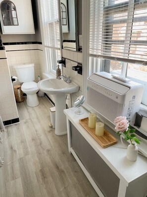 Une salle de bain moderne avec des toilettes, un lavabo et une fenêtre.