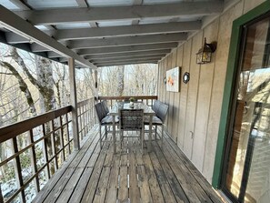 A wooden deck with a table and chairs, a view of trees, and a green-framed window. - * Plentiful Porches * Hot Tub * King Bed * Views * (Watauga County)
