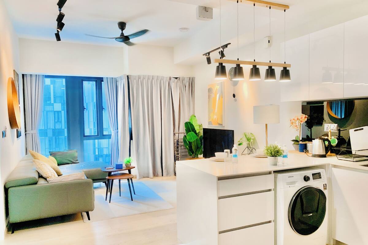 Un appartement moderne comprenant un salon, une cuisine et un espace buanderie.