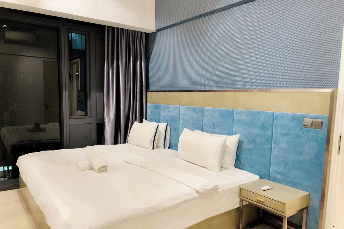 Une chambre d’hôtel avec un grand lit, une table de chevet et une vue sur la ville.