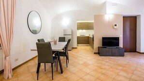 Ein modernes Wohnzimmer mit Essbereich, Küche und Fernseher.