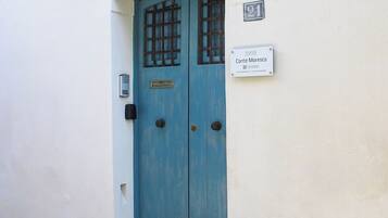 Una porta blu con un motivo a griglia, una cassetta postale e un cartello con su scritto "Conte Moresco".