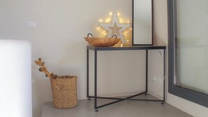 Un rincón con una pequeña consola, un espejo y una estrella decorativa con luces.