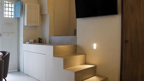 Una cocina moderna con una encimera empotrada y una escalera con iluminación integrada.