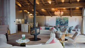 A modern living room with a fireplace, sofas, and a dining area. - Silverstone by Alpine Resorts (Val-d'Isere)