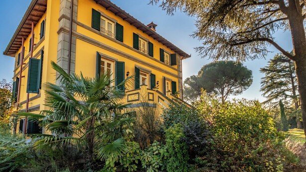 A two-story yellow building with green shutters, surrounded by lush greenery and trees. - *Elegant Villa*with Private Park-10 min from LUCCA (Capannori)