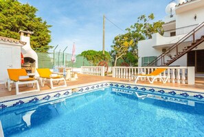 A swimming pool with tiled edges, surrounded by white railings and yellow lounge chairs. - Villa Praia in Albufeira (Albufeira)