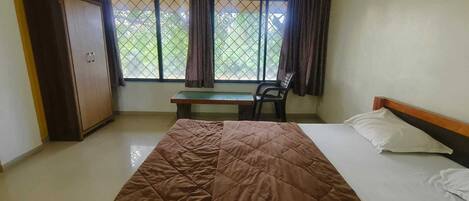 A room with a bed, a desk, and a chair.
