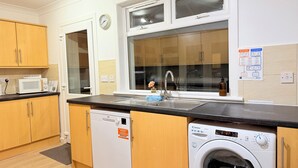 A compact kitchen with a microwave, dishwasher, and washing machine. - RF-Entire House -Central Scotland-Falkirk| Self-Check-in |Pet-friendly | Parking (Falkirk)