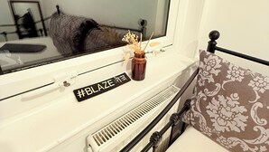 A bedroom with a bed, a window, a radiator, and a small table with a decorative item. - RF-Entire House -Central Scotland-Falkirk| Self-Check-in |Pet-friendly | Parking (Falkirk)