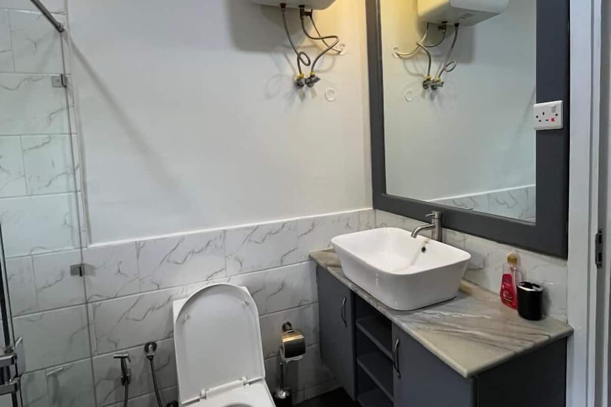 Casa de banho moderna com sanita, lavatório e secador de mãos.