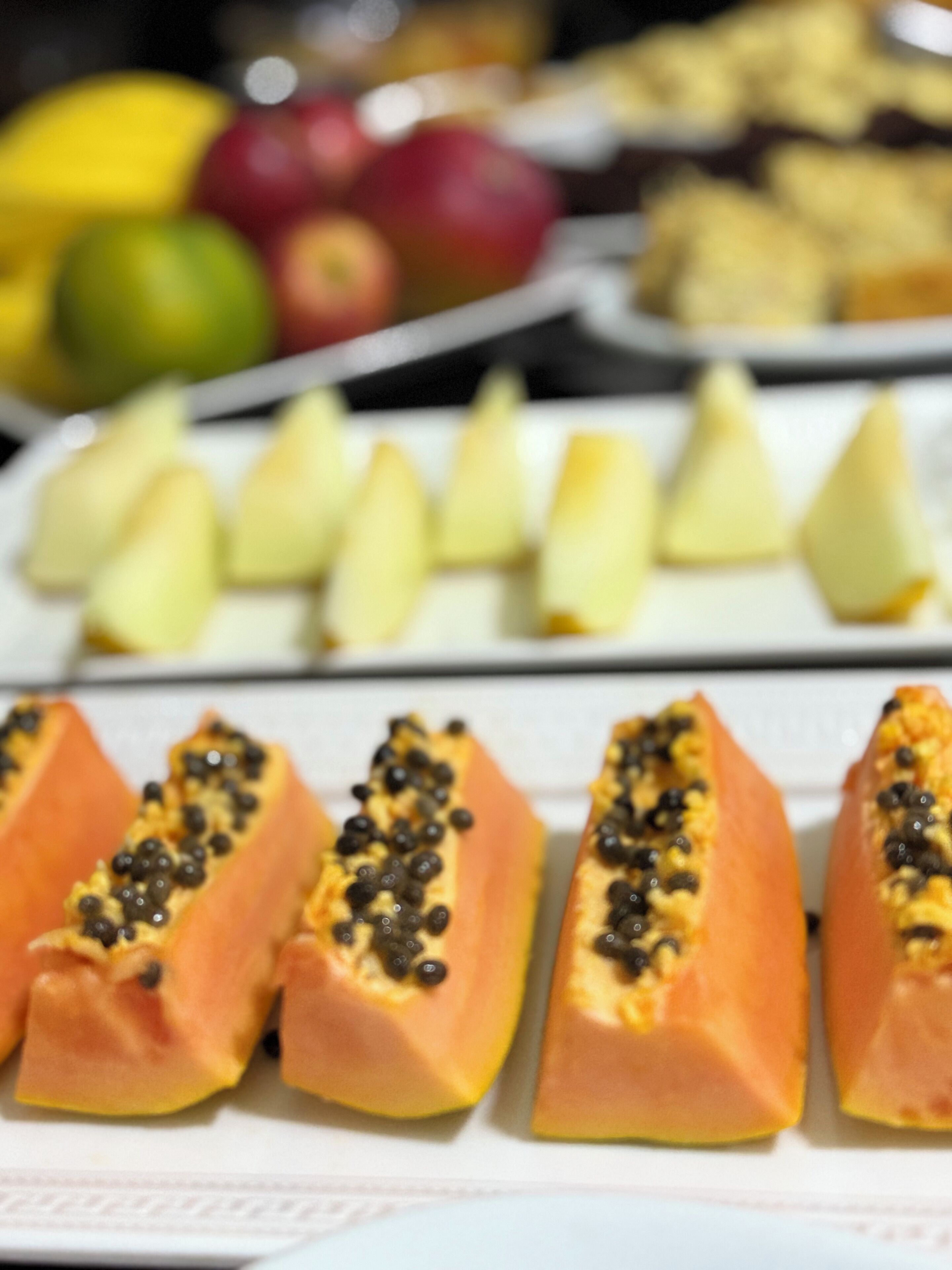 Un plato de comida con papaya y rodajas de manzana.