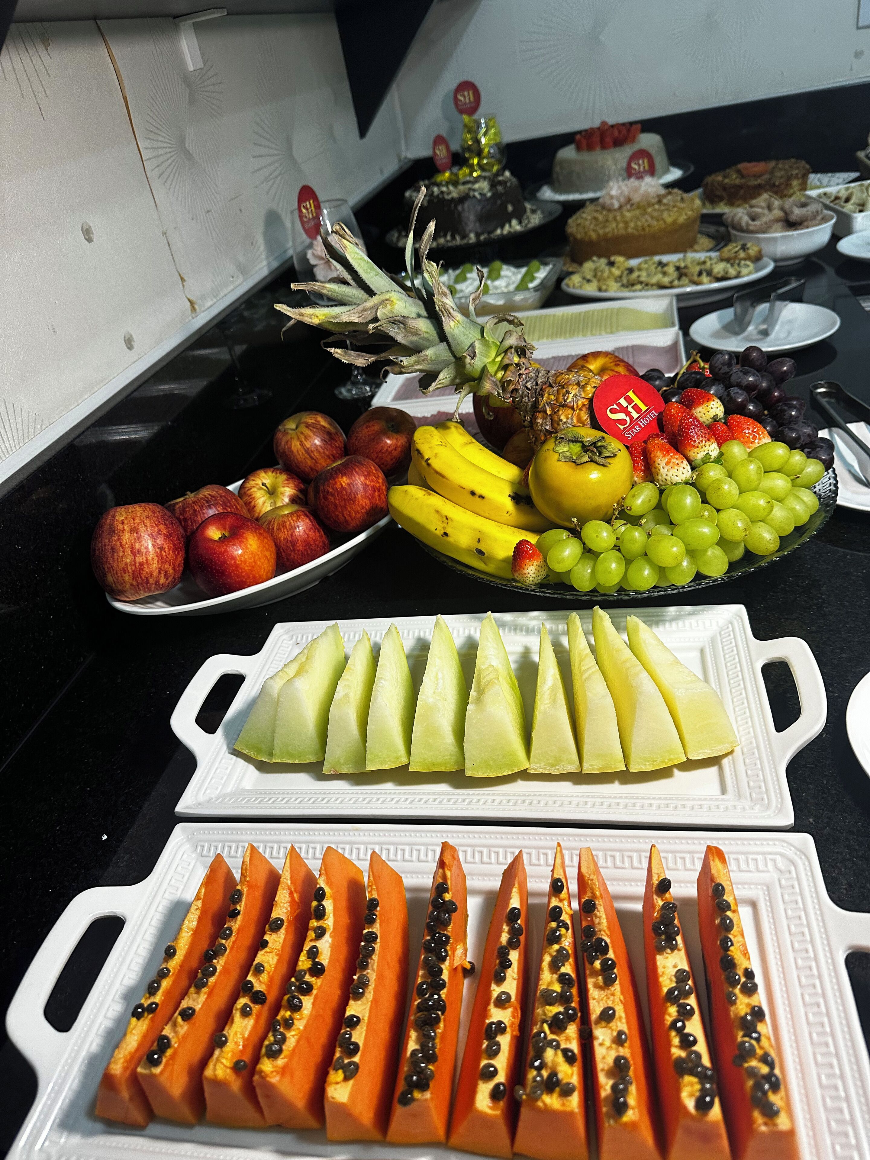 Una mesa de buffet con diversas frutas y postres.