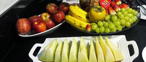 Una mesa de buffet con diversas frutas y postres.