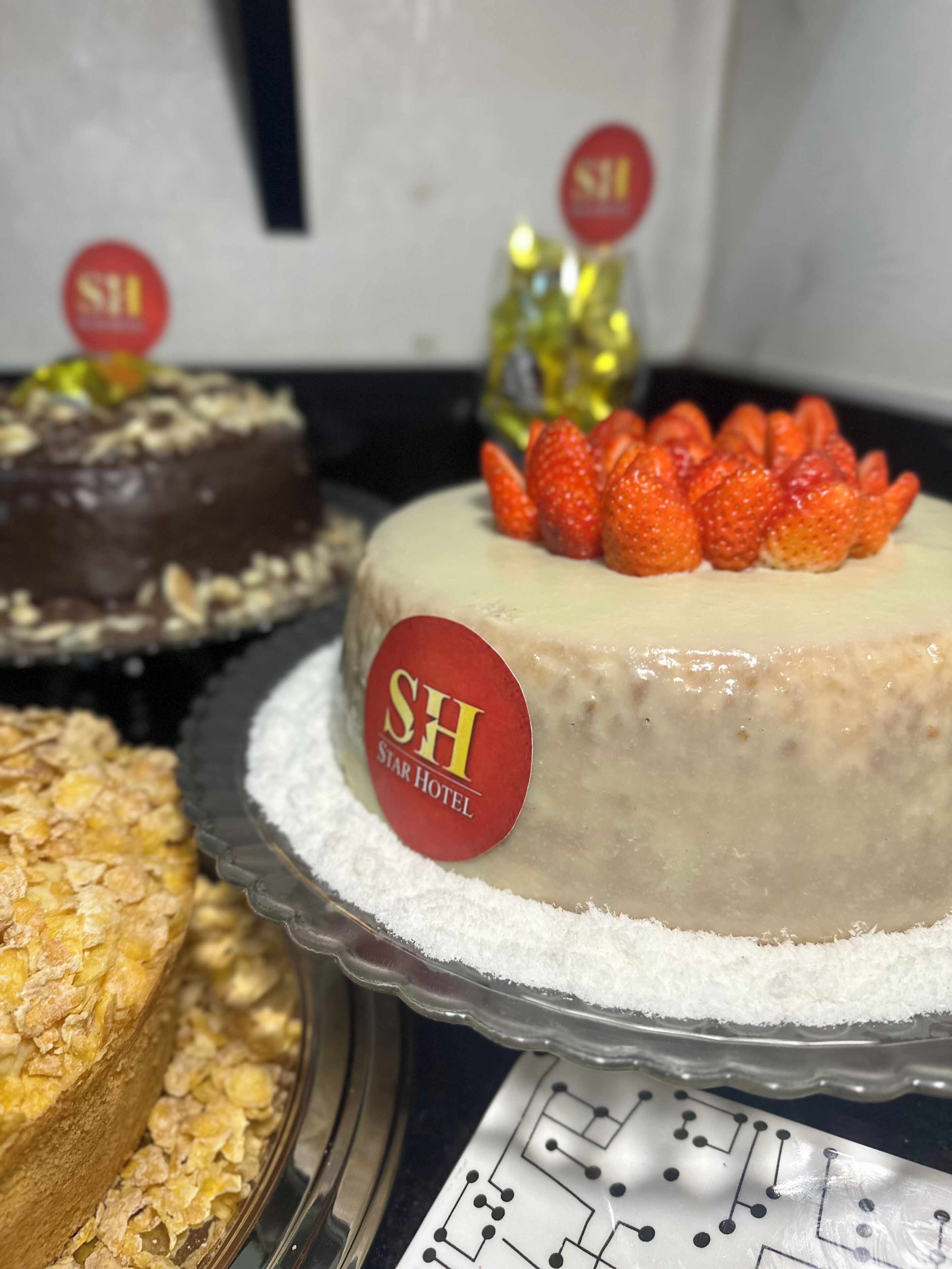 A cake with strawberries on top and a label that reads "SH STAR HOTEL".