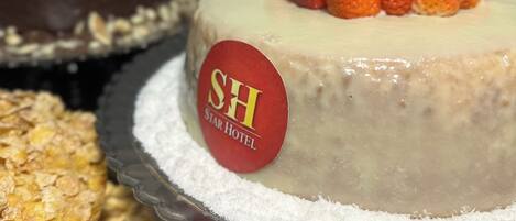 A cake with strawberries on top and a label that reads "SH STAR HOTEL".