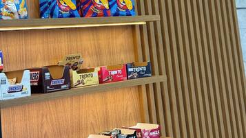 A snack display with various brands including Trento, Snickers, and Halls.