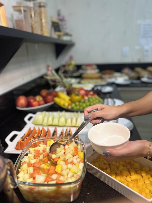 Un bufé con diversas frutas y verduras, como manzanas, naranjas y zanahorias.