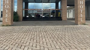 The Star Hotel entrance with a modern design, featuring a glass facade and a brick-paved entrance area. - STAR HOTEL (Chapecó)