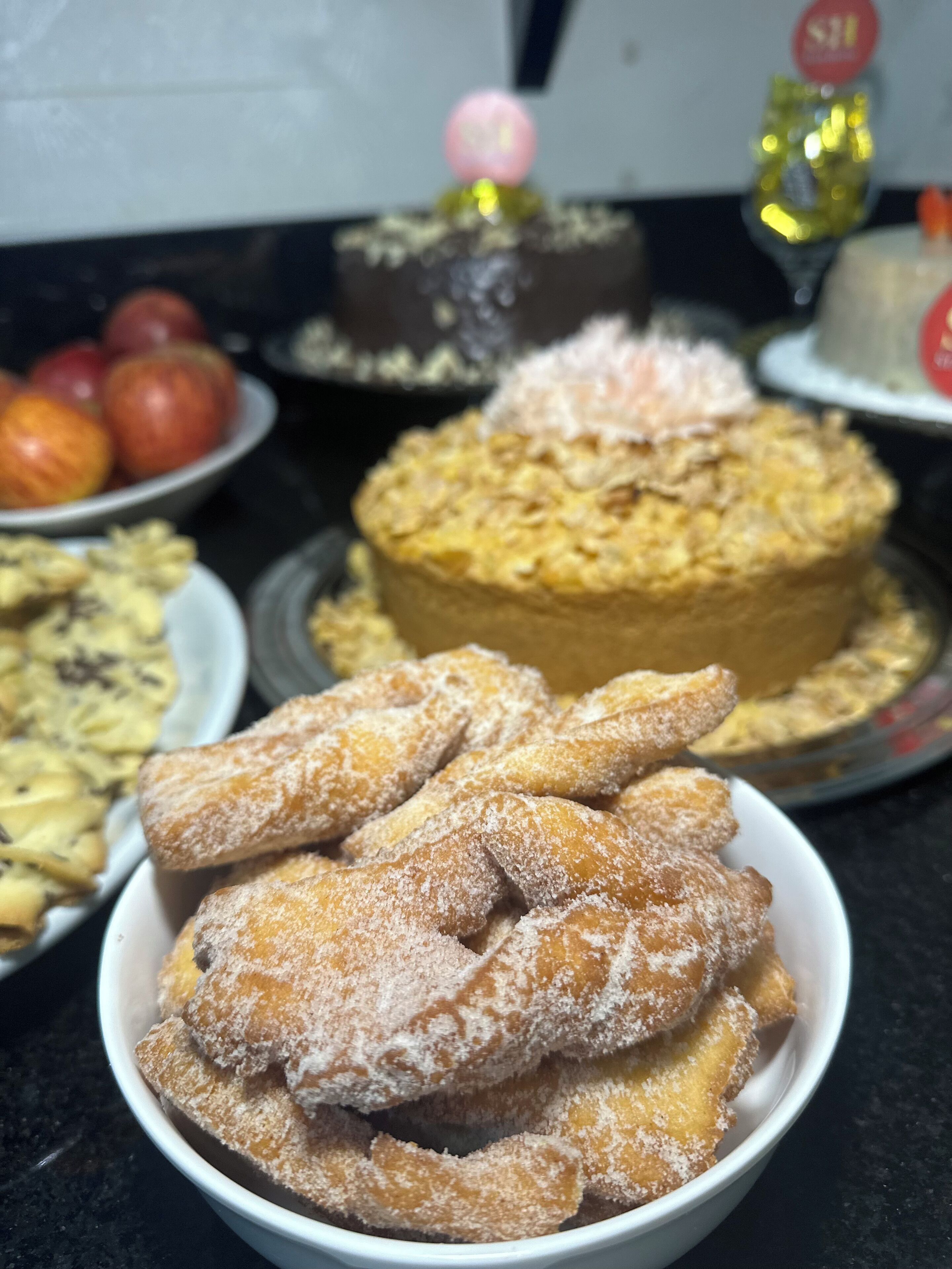 A variety of desserts including a cake, pastries, and fruit on a table.