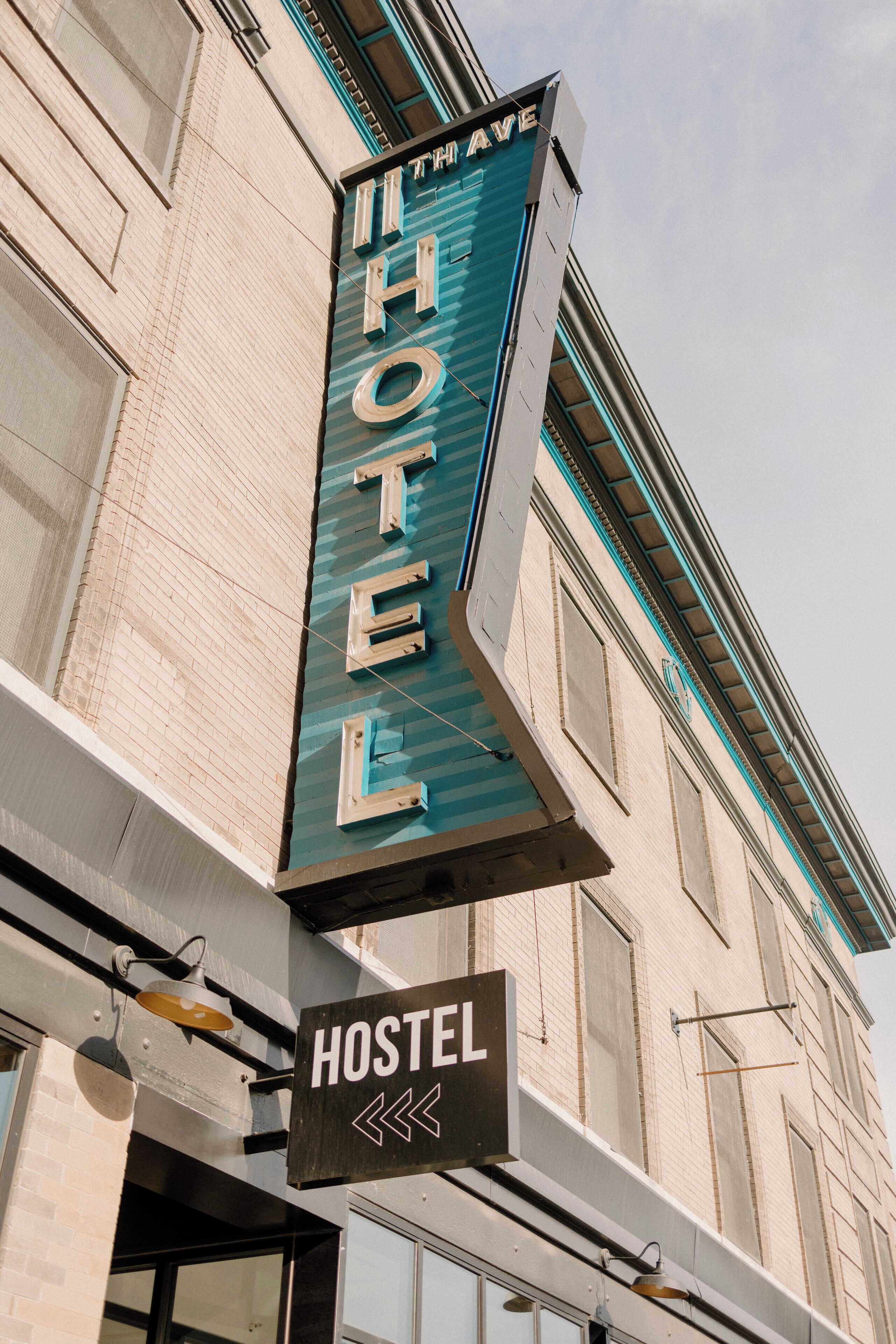 Un letrero de hotel con el nombre "The Wave Hotel" y un letrero de hostal debajo.