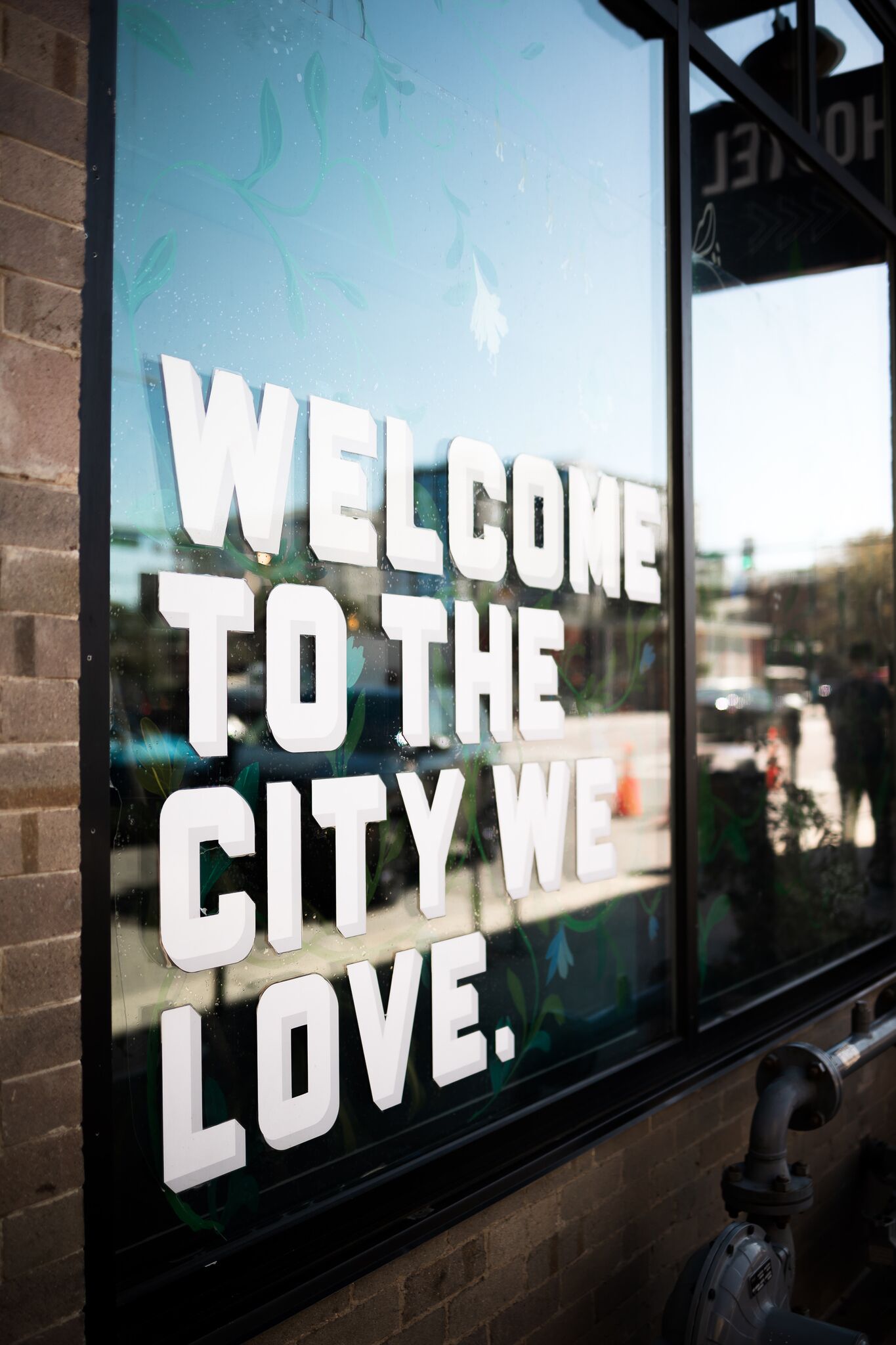 A window with the text "WELCOME TO THE CITY WE LOVE."