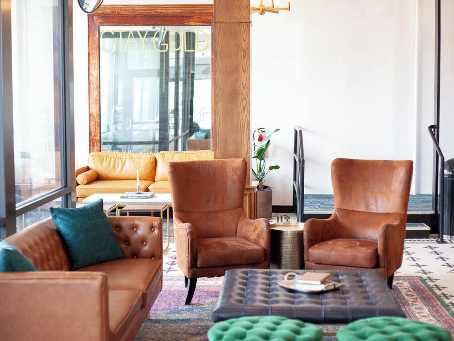 Een moderne woonkamer met leren fauteuils, een bank en een salontafel.