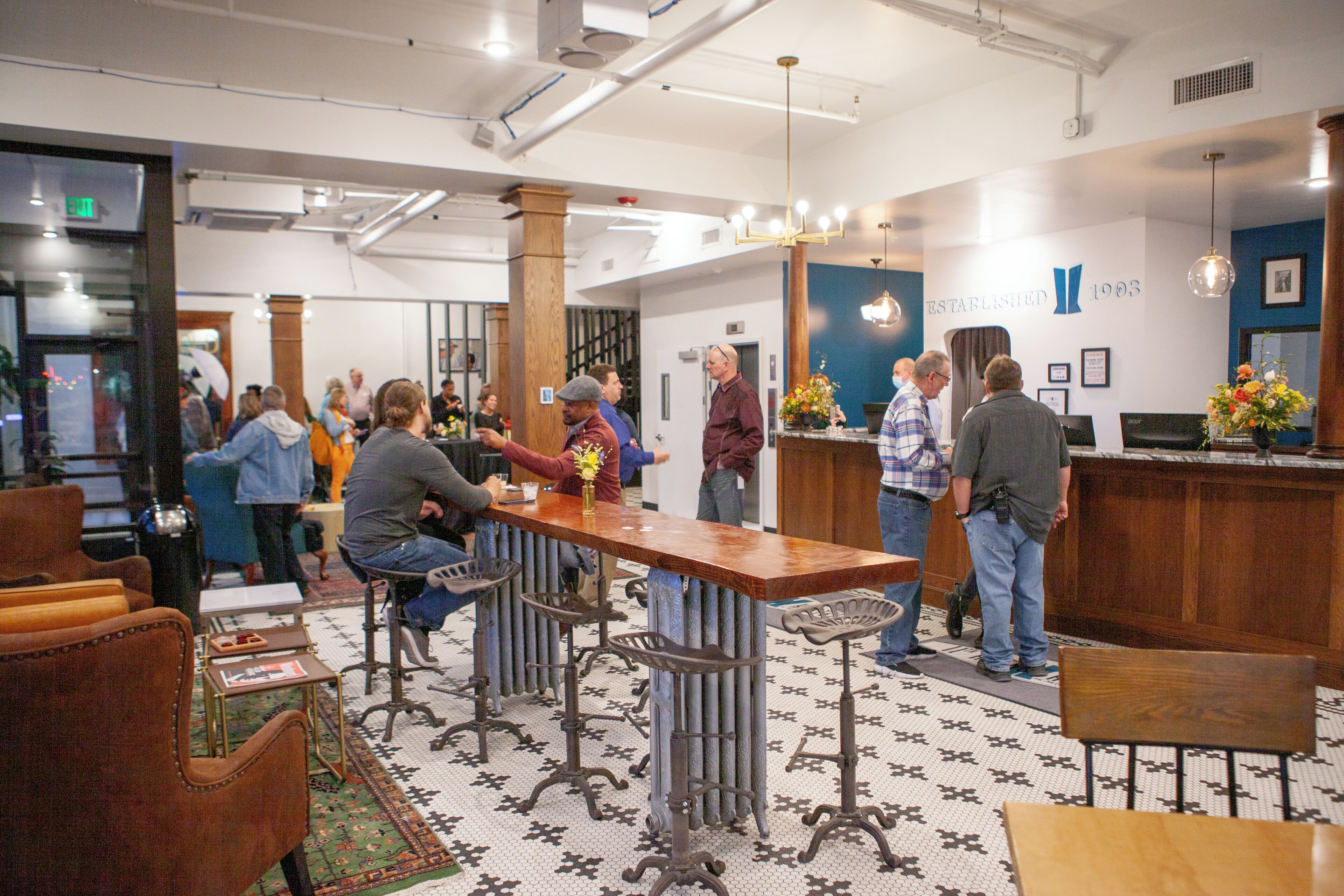 A bar area with stools, a wooden counter, and a patterned floor.