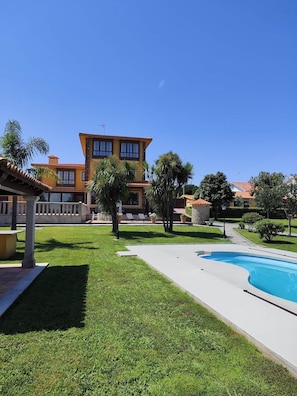 A pool, a well-maintained lawn, and a building with a tiled roof. - Donato House (Narón)