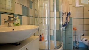 A bathroom with a white sink, a glass shower enclosure, and a toilet. - Comfortable and Sunny Rovinj Apartment (Rovinj)