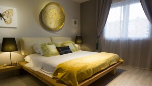 A modern bedroom with a wooden bed, white bedding, and decorative pillows. There are two bedside tables with lamps and a wall art piece. - Scenic Rovinj Apartment With Balcony (Rovinj)