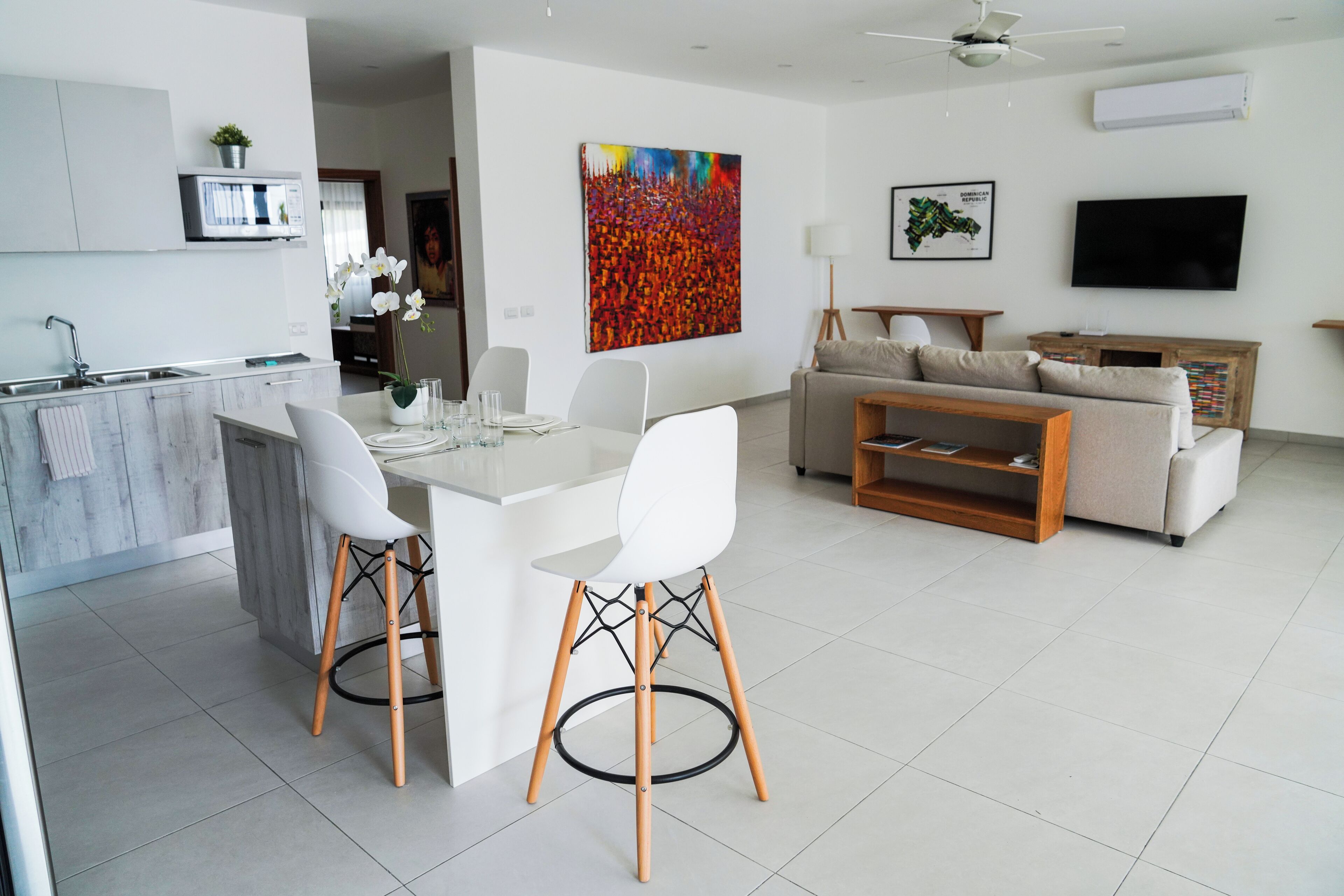 A modern living space with a kitchen, dining area, and a living room.