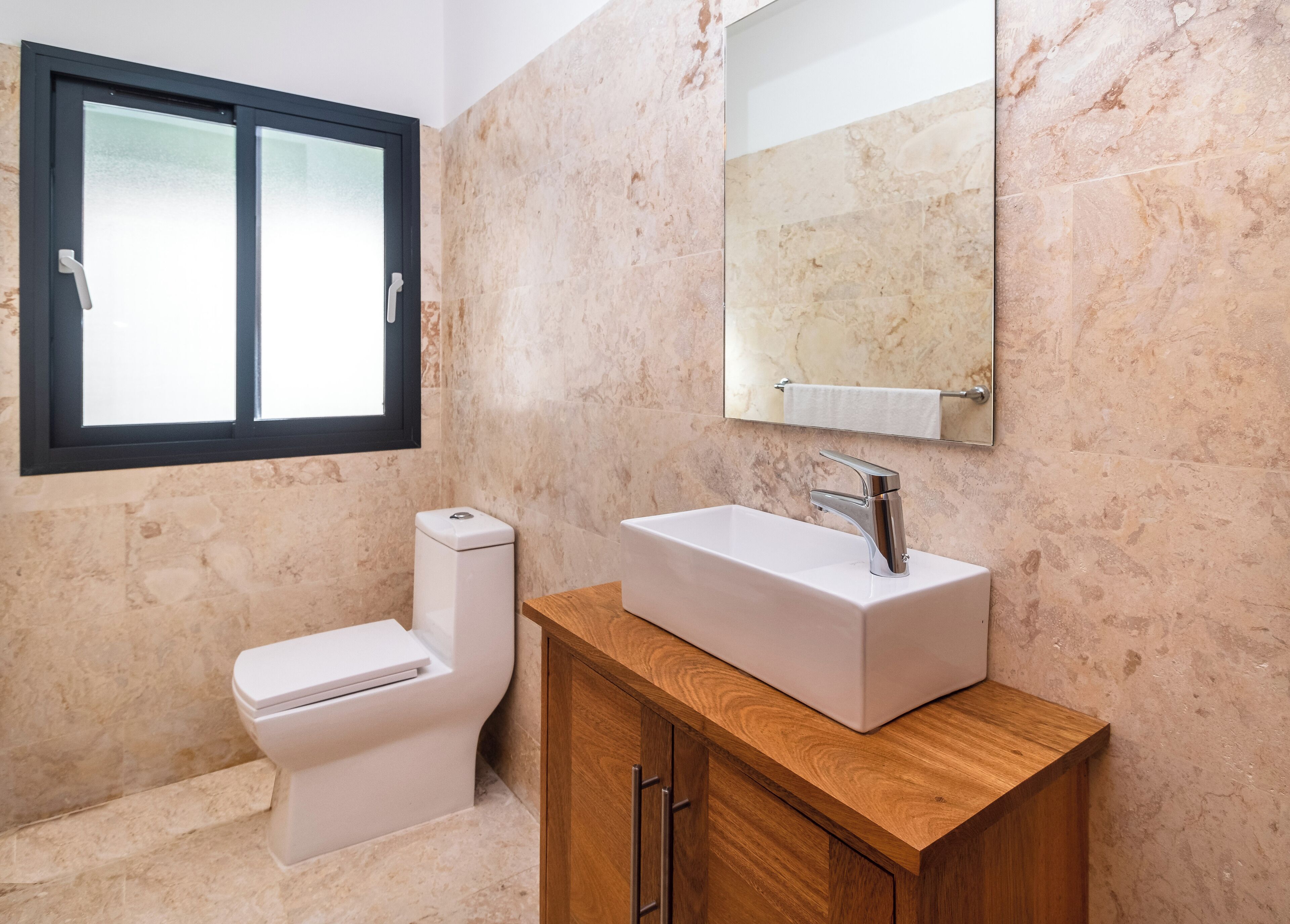 Une salle de bain avec des toilettes, un lavabo et un miroir.
