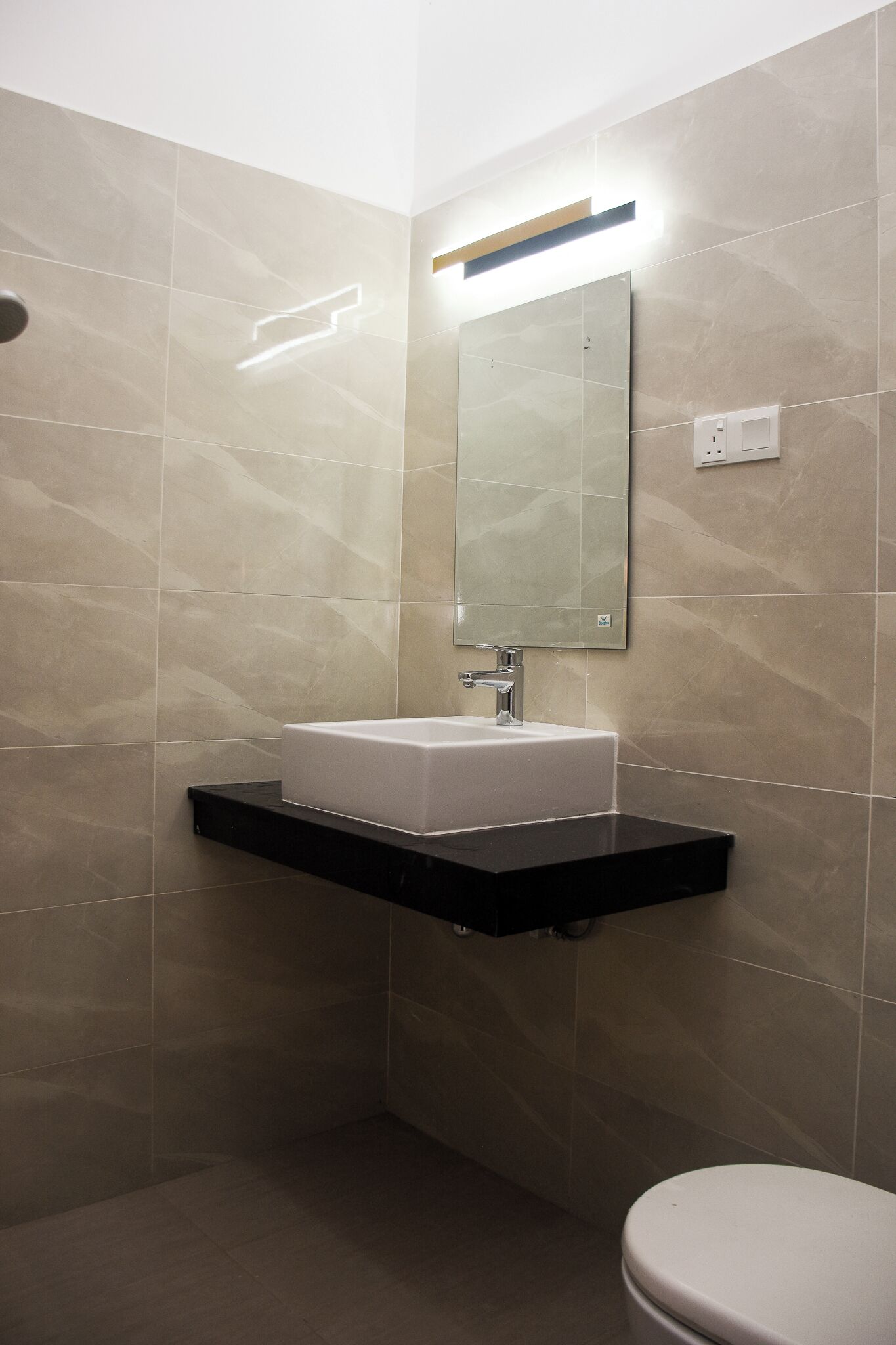 A bathroom with a white sink, a mirror, and a toilet.