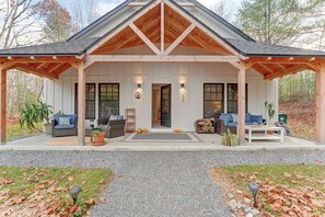 Et moderne hus med en overdækket veranda, store vinduer og en indbydende indgang.