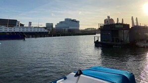 A waterfront view with a large building, a smaller structure, and a docked boat. - Ringö Resort (Gothenburg)
