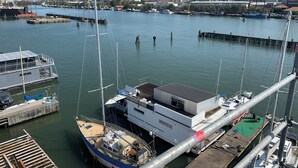 A marina with boats docked, a large ship, and a building with a flat roof. - Ringö Resort (Gothenburg)