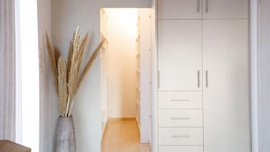 A hallway with a tall cabinet and a vase of dried plants. - Peach- Sea View Exclusive Maisonette (Rethymno)